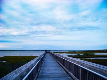 Bridge over calm sea against sky