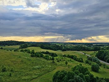 Scenic view of field against cloudy sky