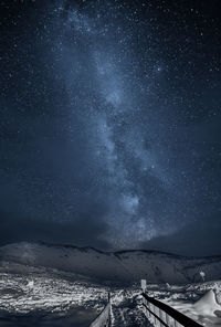 Scenic view of snowcapped mountains against sky at night