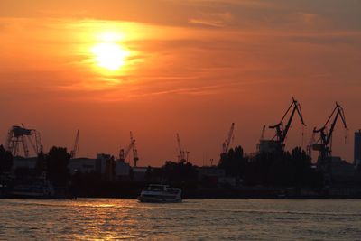 Boats in calm sea at sunset
