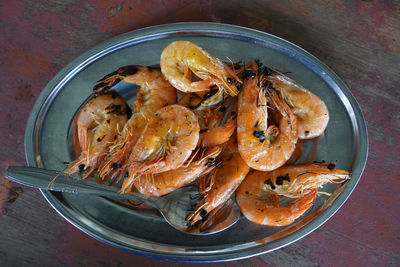 Grilled shrimps served in tin plate on the table