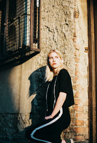 Portrait of woman standing against wall