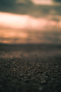 Surface level of land against sky during sunset