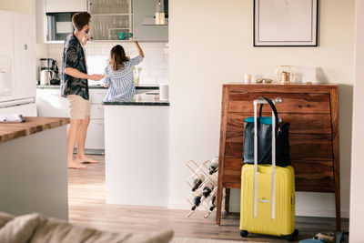 Couple working in kitchen together at apartment during staycation