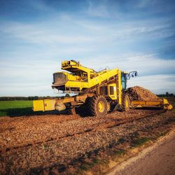 Yellow construction site on field against sky