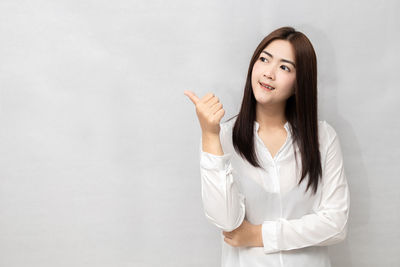 Portrait of a smiling young woman against white background