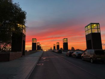 Cars on road against sky during sunset