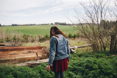 Rear view of woman standing on field