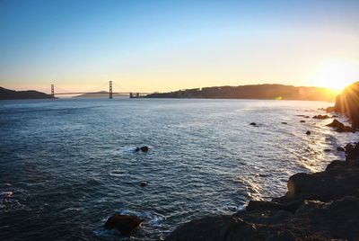 Sun shining through clouds over sea