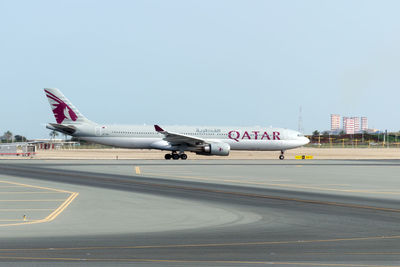 Airplane on runway against sky