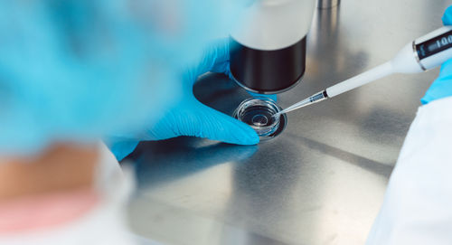 Close-up of scientist hand holding microscope