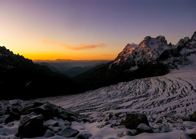 Scenic view of snowcapped mountains against sky during sunset