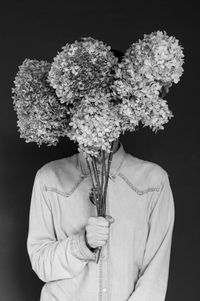 Man holding flowers against black background