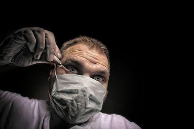 Portrait of man against black background