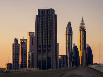 Modern buildings against sky during sunset