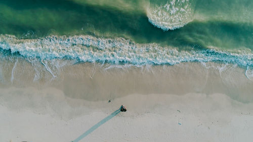 High angle view of man standing on sea shore