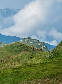 Rear view of man walking on mountain against sky
