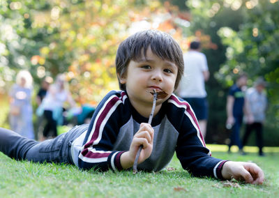 Young woman blowing bubbles while sitting on field