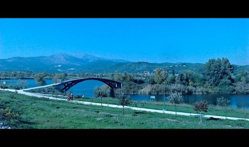 Bridge over river against clear blue sky