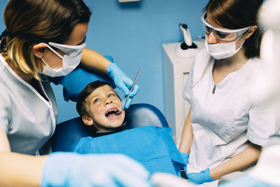 Dentist operating boy in medical clinic