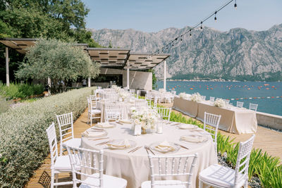 Empty chairs and tables and table by sea
