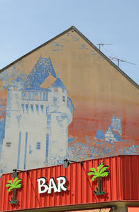 Low angle view of text on building against sky