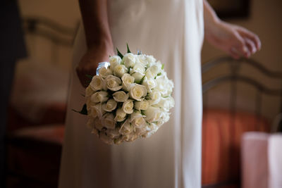 Midsection of bride holding bouquet
