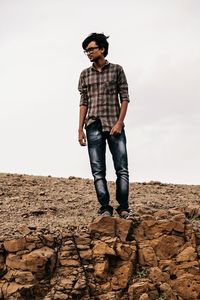 Full length of young man standing on rock