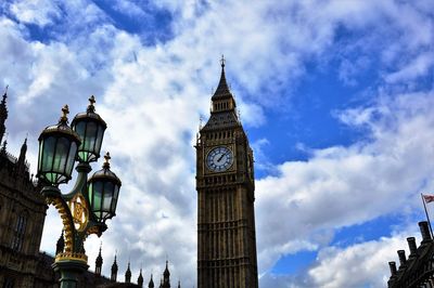 Low angle view of clock tower against cloudy sky