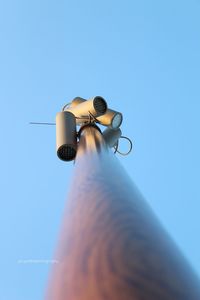 Low angle view of camera against clear blue sky