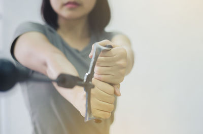 Midsection of woman standing against white background