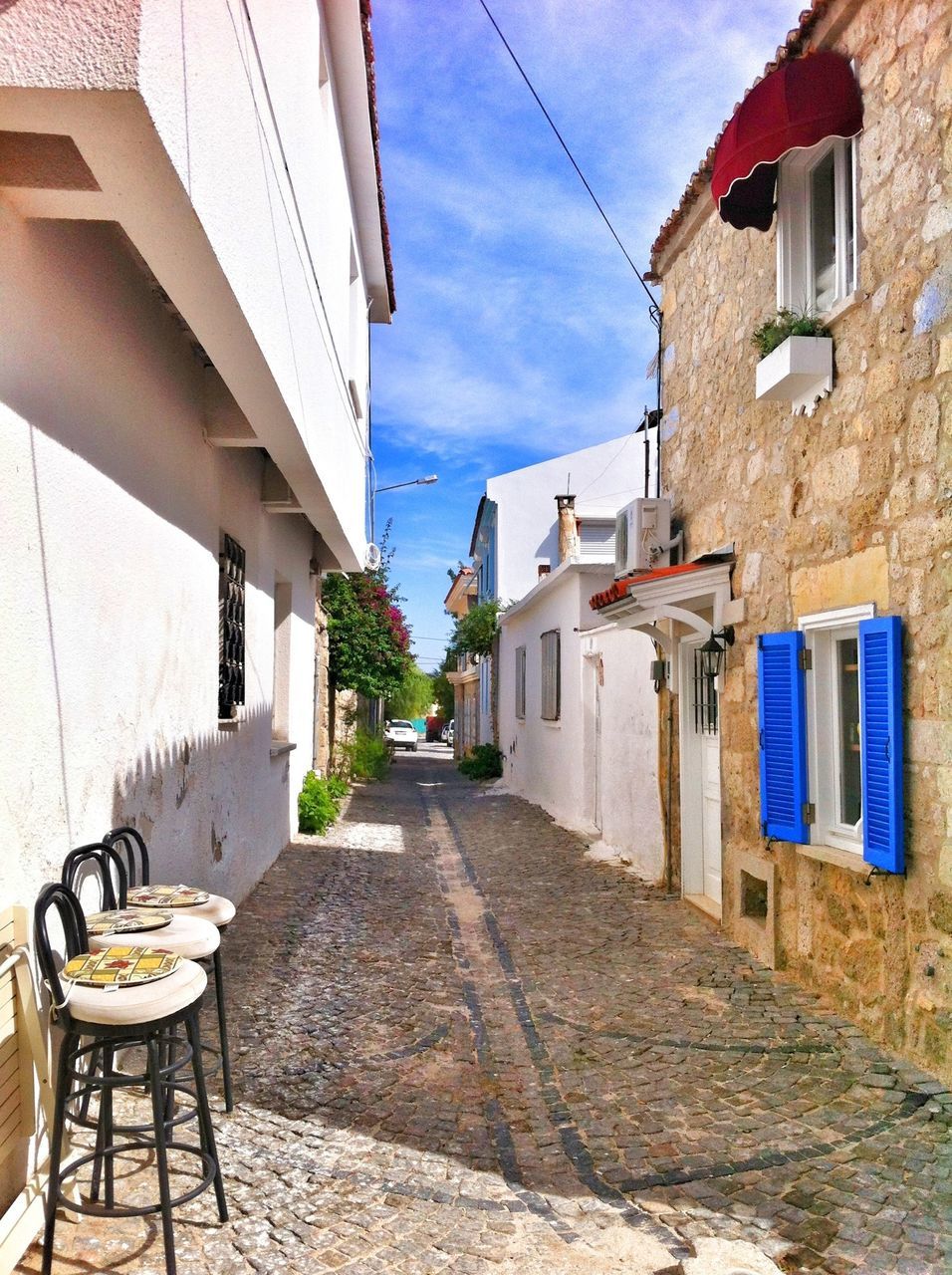 architecture, building exterior, built structure, the way forward, residential building, house, residential structure, street, narrow, building, sky, alley, diminishing perspective, empty, day, potted plant, town, sunlight, blue, city