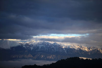 Scenic view of snowcapped mountains against sky during sunset