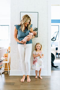 Straight on portrait of a mother and two daughters in a modern house