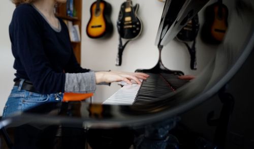 Midsection of man playing guitar