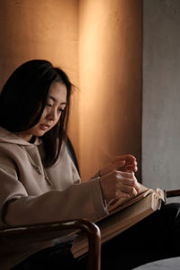 Young woman using mobile phone while sitting at home