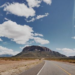 Scenic view of road by mountain against sky