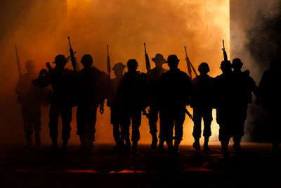 Silhouette group of thai soldiers special forces full team in uniform walking action through smoke 
