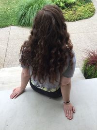 High angle rear view of woman sitting on steps