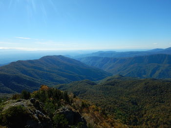 Scenic view of mountains against blue sky