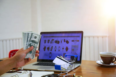 Midsection of woman using smart phone on table
