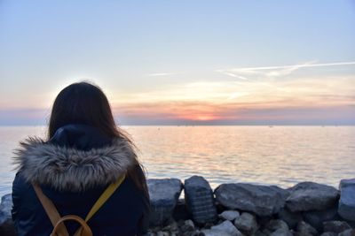 Rear view of woman looking at sea against sky