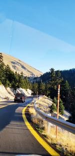 Cars on road against clear blue sky