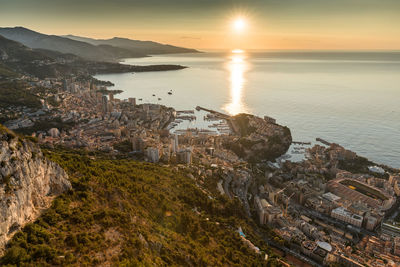 High angle view of townscape by sea against sky during sunset