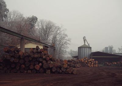 Stack of logs against sky