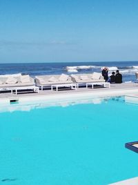 People at swimming pool against sky