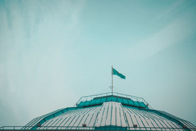 Low angle view of flags on building against sky