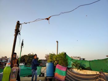 People standing by plants against clear sky