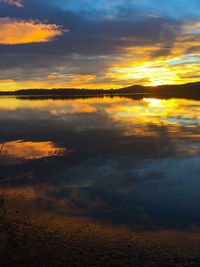 Scenic view of sea against cloudy sky at sunset