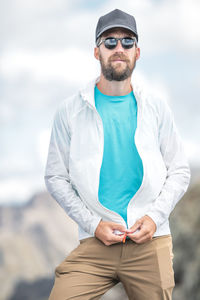 Portrait of young man standing against sky